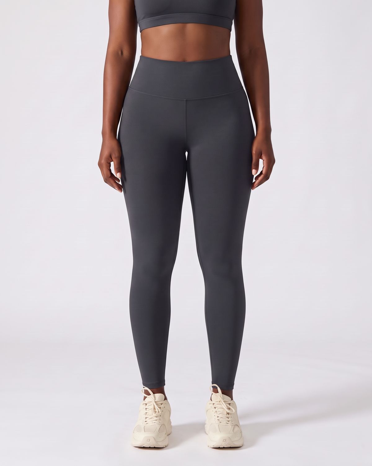Legging AIKISculpt gris porté sur fond clair, vue de face, de la poitrine aux pieds