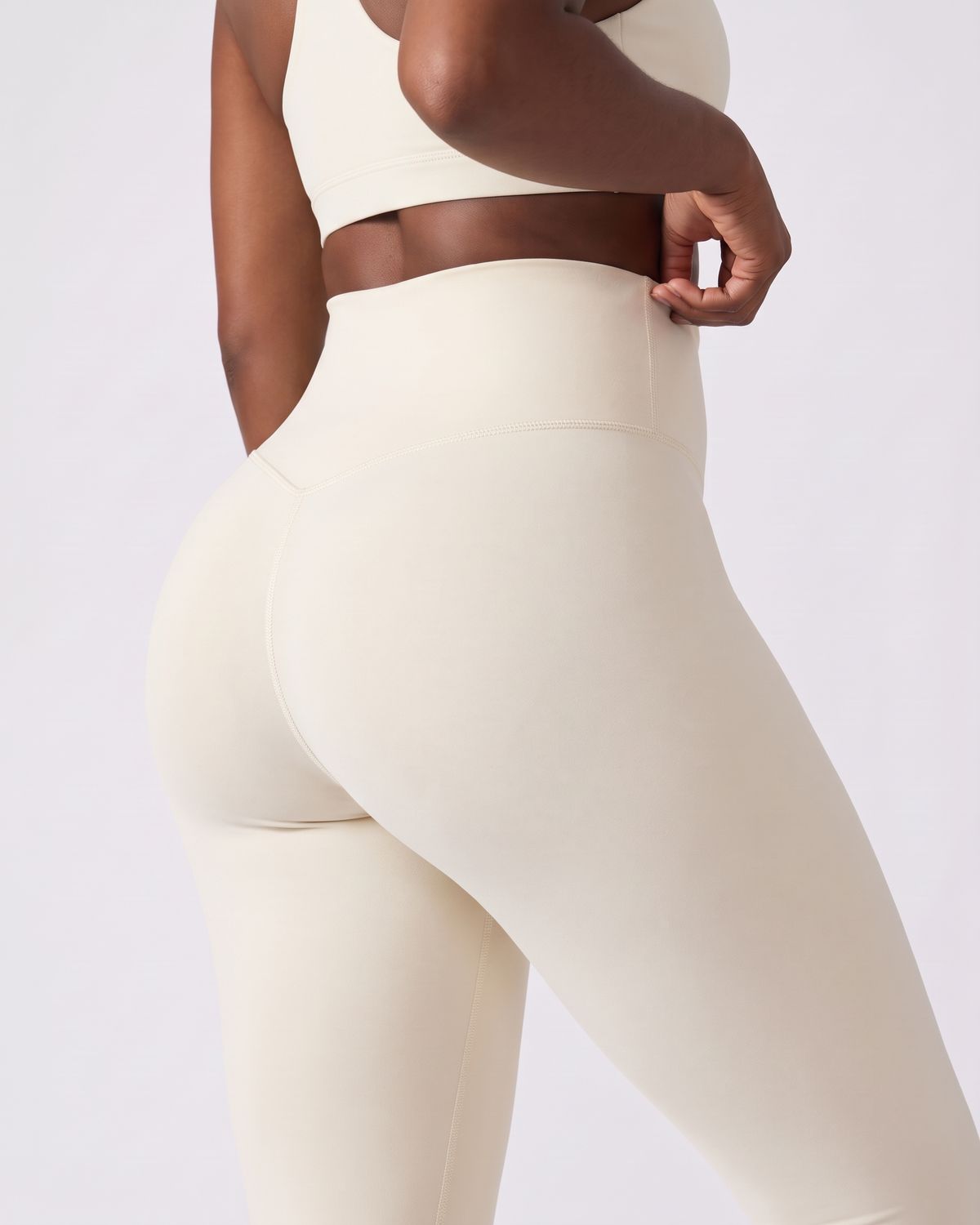 Legging AIKISculpt ivoire porté sur fond clair, gros plan de dos sur la ceinture large et le galbe des fessiers