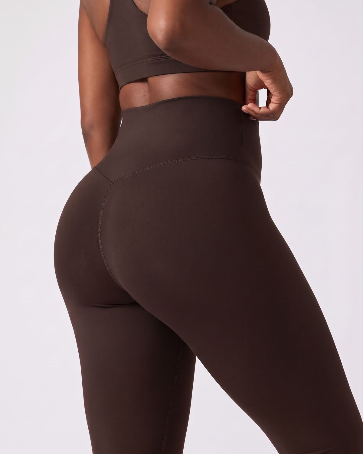 Legging AIKISculpt marron porté sur fond clair, gros plan de dos sur la ceinture large et le galbe des fessiers
