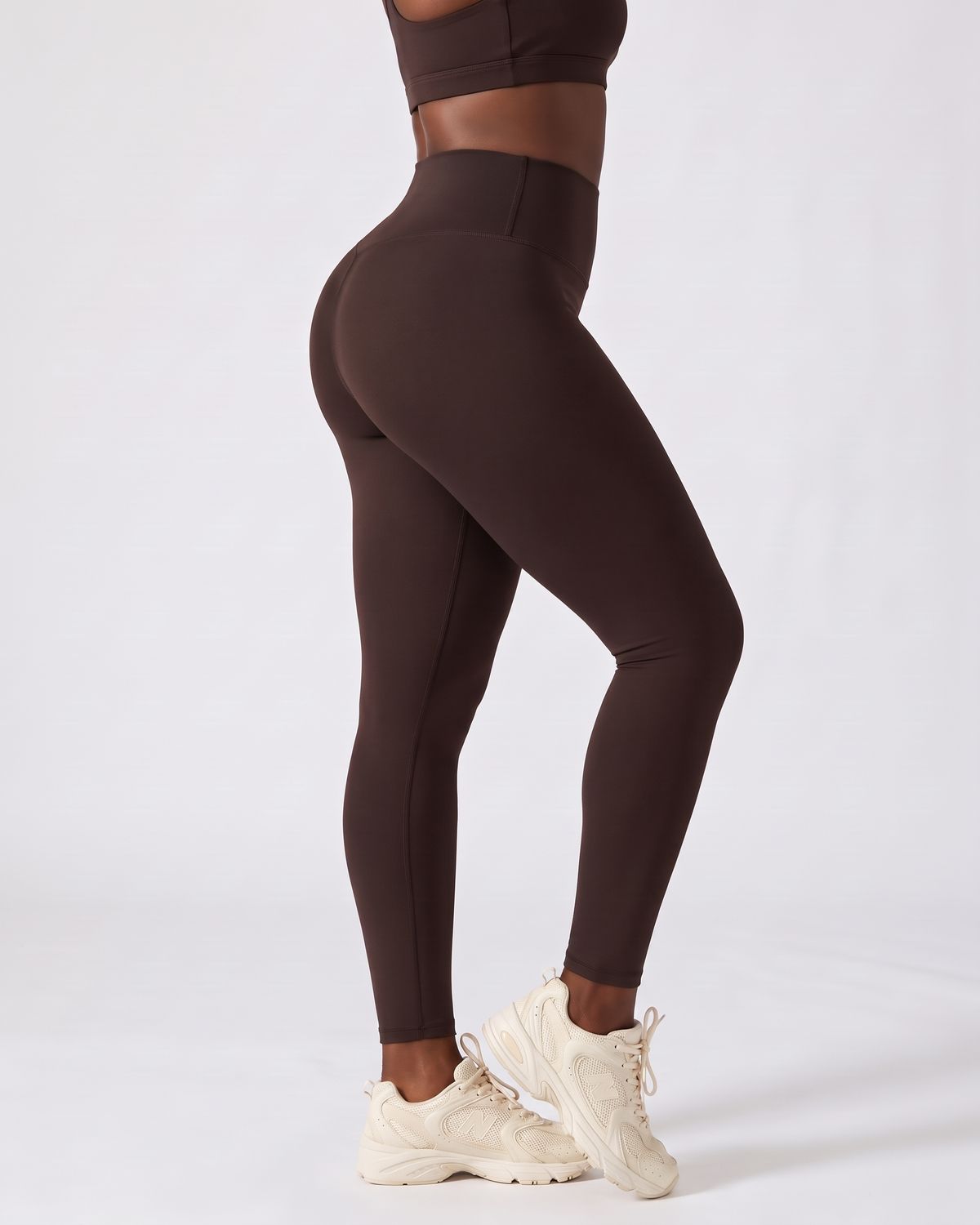 Legging AIKISculpt marron porté sur fond clair, vu de trois quarts dos, de la poitrine aux pieds