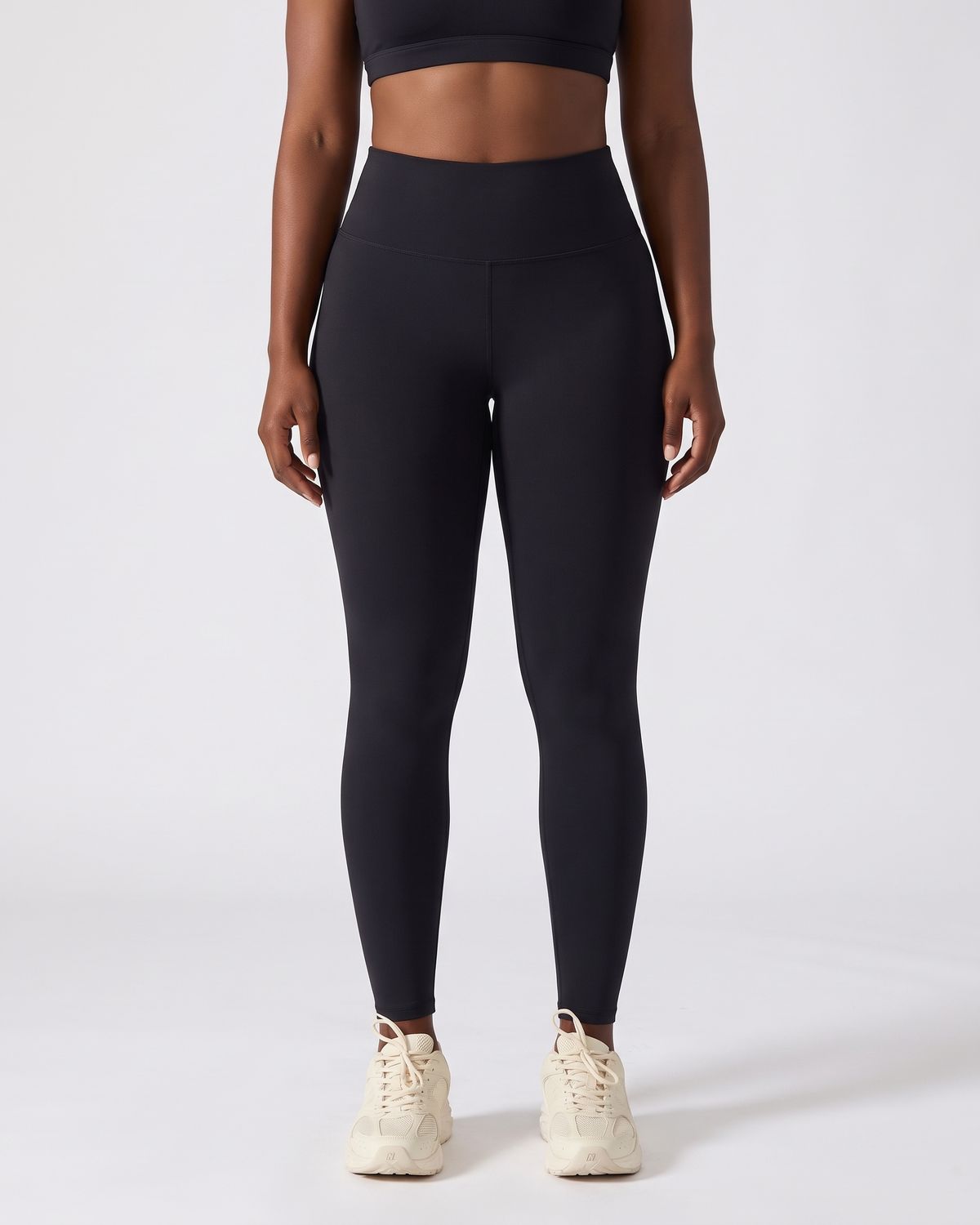 Legging AIKISculpt noir porté sur fond clair, vue de face, de la poitrine aux pieds