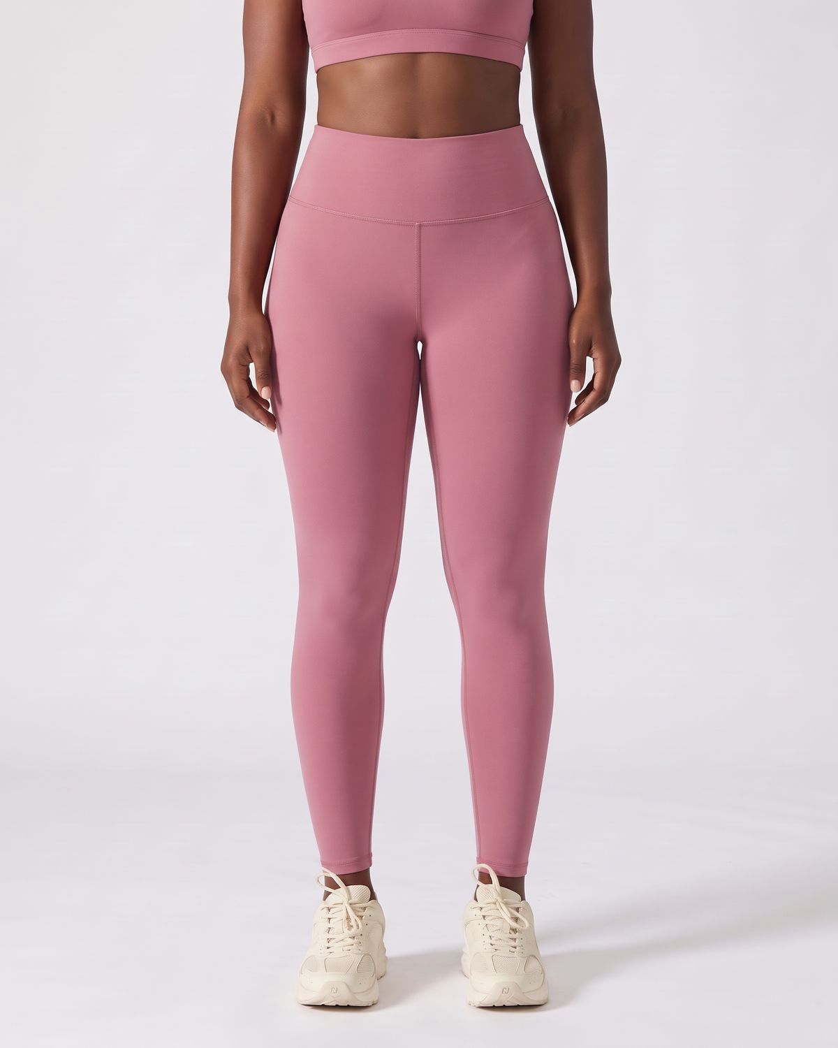 Legging AIKISculpt rose porté sur fond clair, vue de face, de la poitrine aux pieds