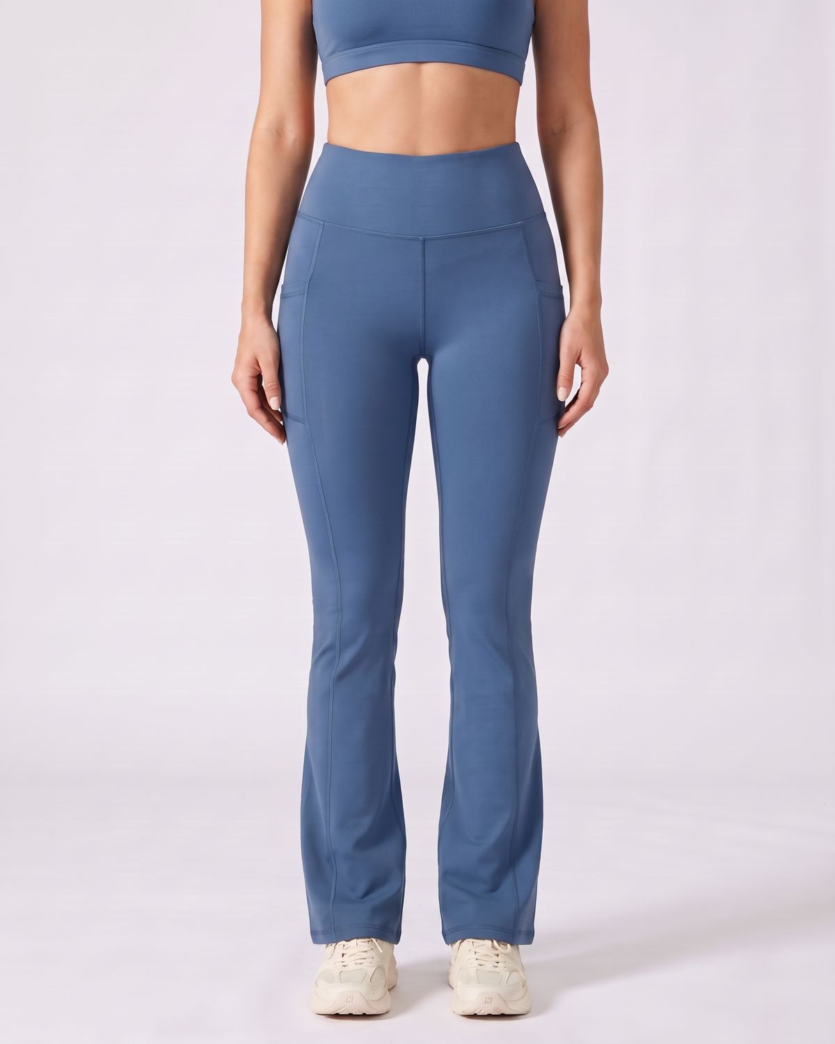 Legging Flare AIKISculpt bleu porté sur fond clair, vue de face, de la poitrine aux pieds