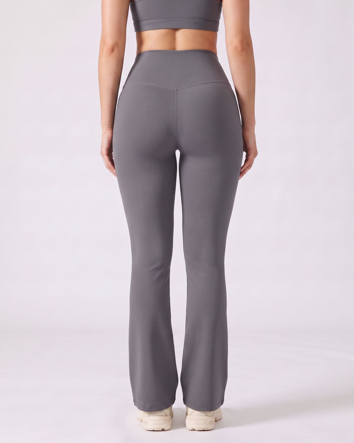 Legging Flare AIKISculpt gris porté sur fond clair, vu de dos, ceinture en V au dos