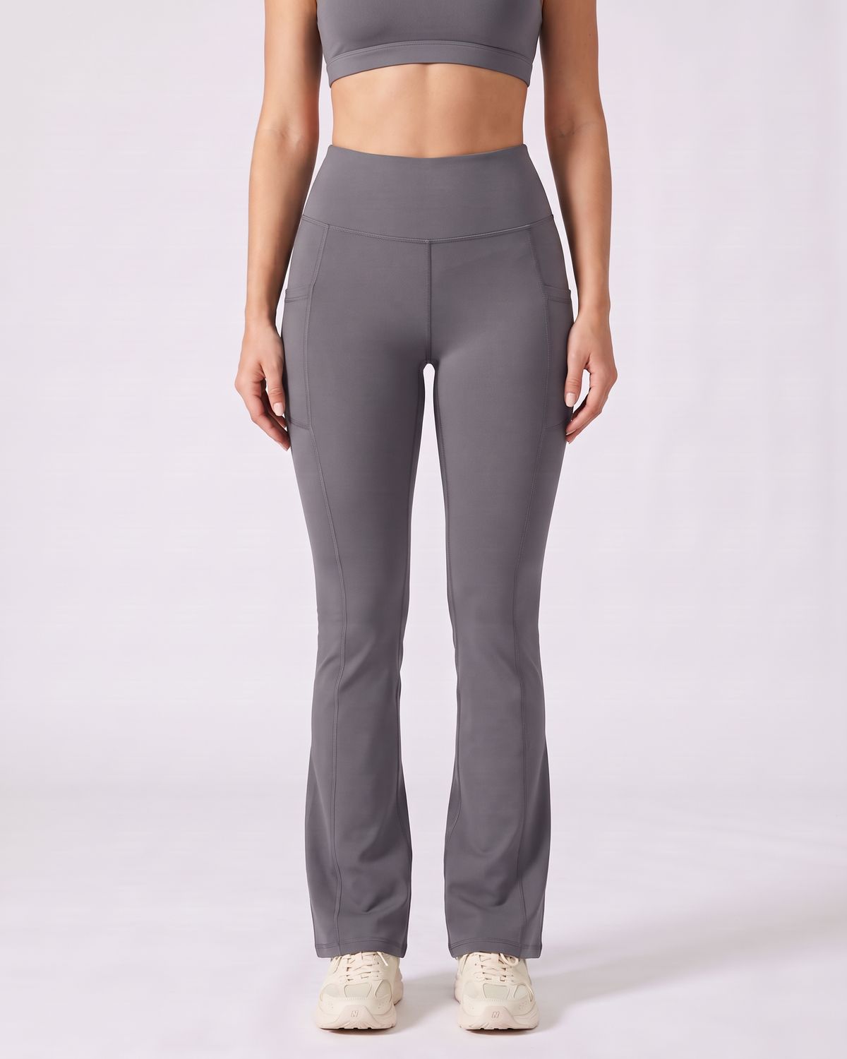 Legging Flare AIKISculpt gris porté sur fond clair, vue de face, de la poitrine aux pieds