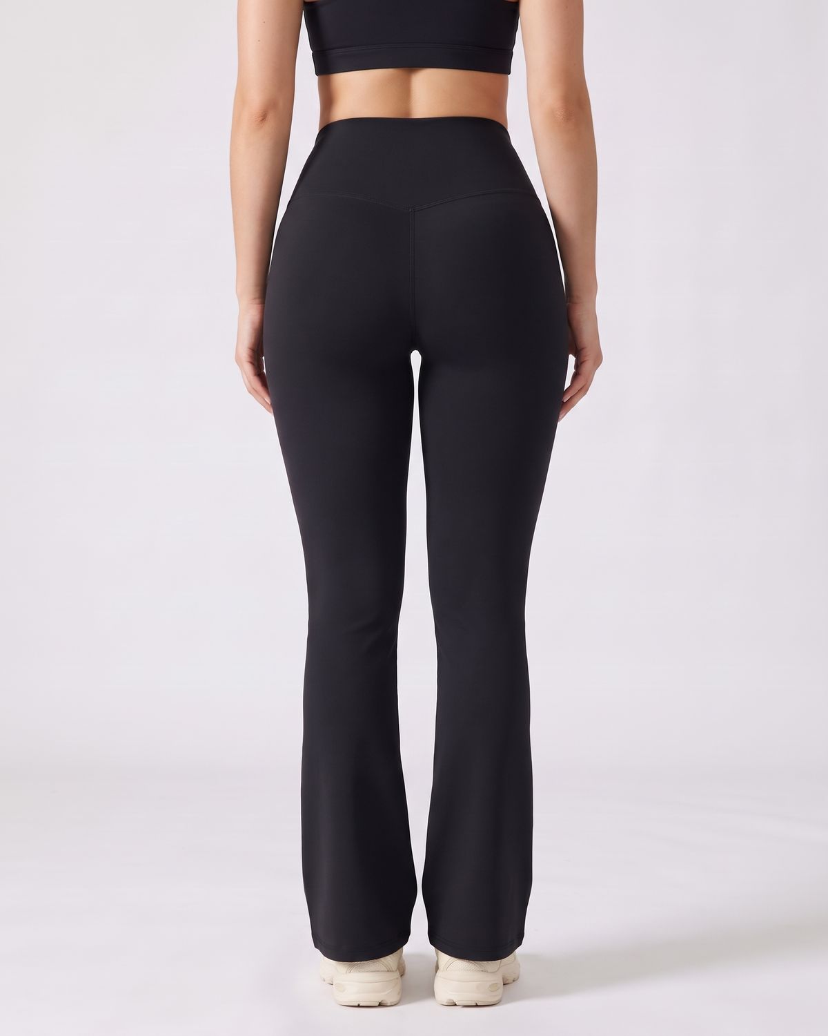 Legging Flare AIKISculpt noir porté sur fond clair, vu de dos, ceinture en V au dos