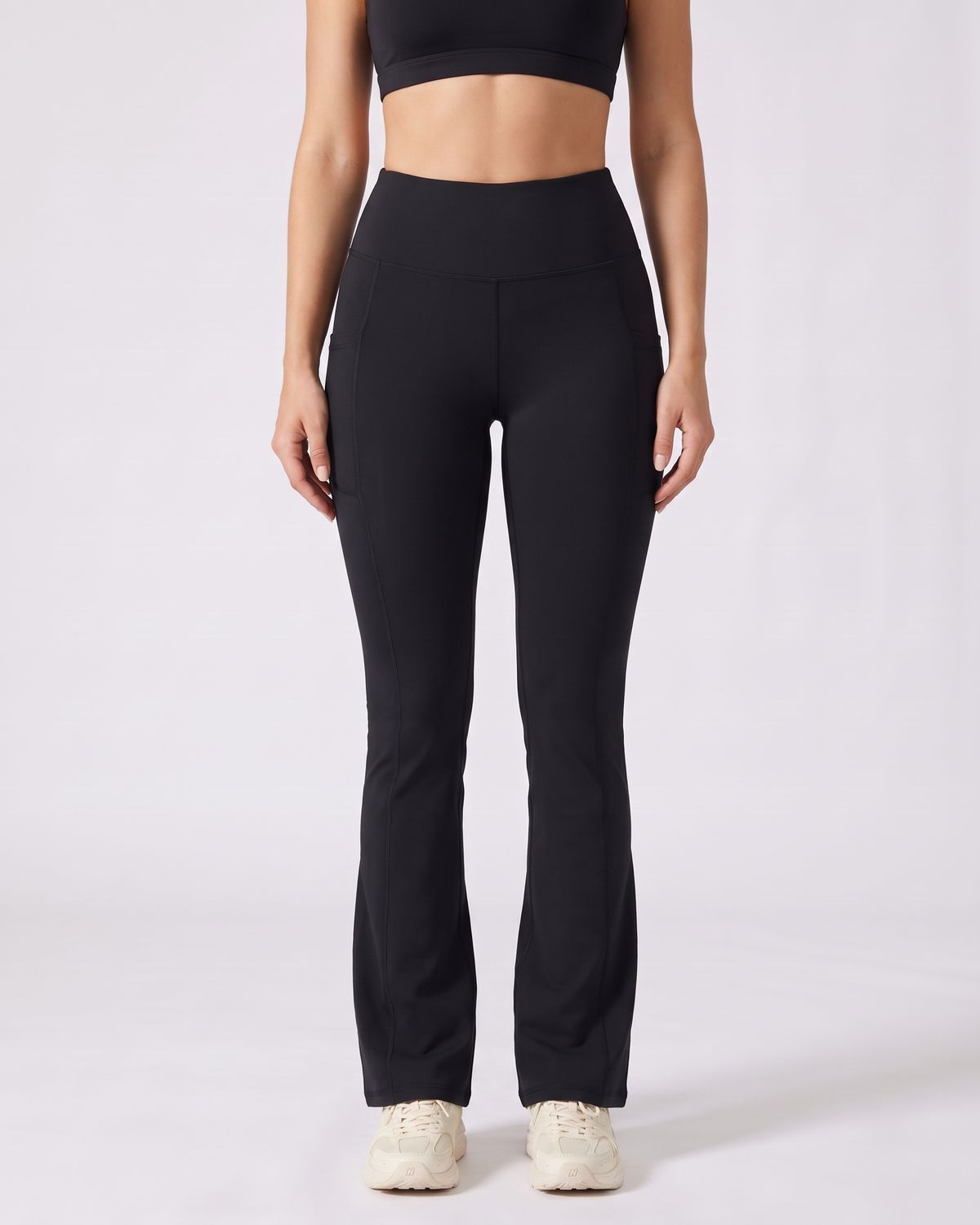 Legging Flare AIKISculpt noir porté sur fond clair, vue de face, de la poitrine aux pieds