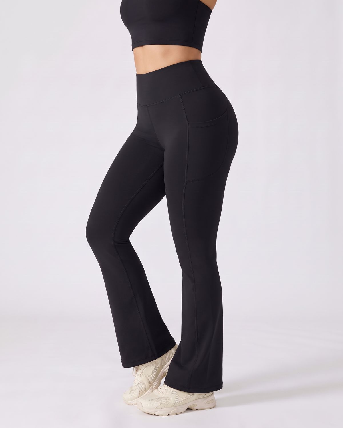 Legging Flare AIKISculpt noir porté, vu de trois quarts sur fond clair, de la poitrine aux pieds, évasé à partir du genou
