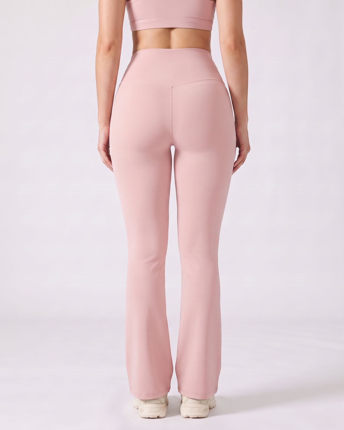 Legging Flare AIKISculpt rose porté sur fond clair, vu de dos, ceinture en V au dos