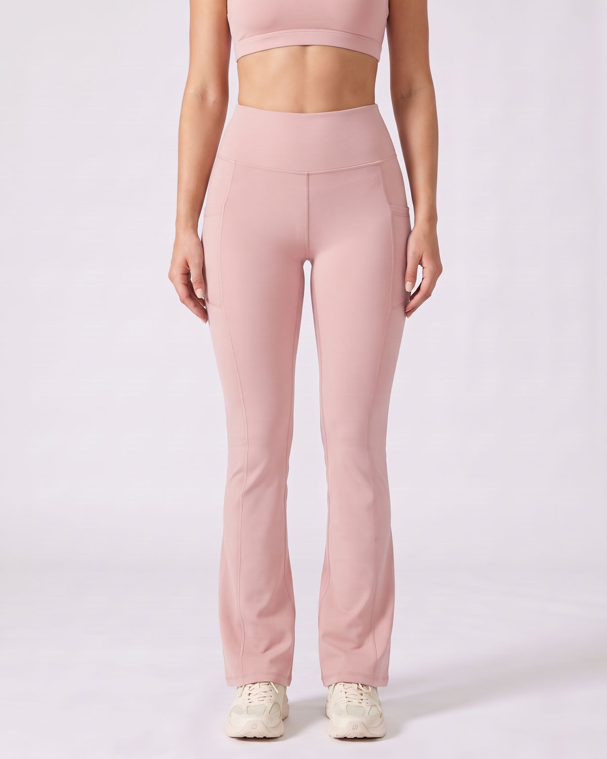 Legging Flare AIKISculpt rose porté sur fond clair, vue de face, de la poitrine aux pieds