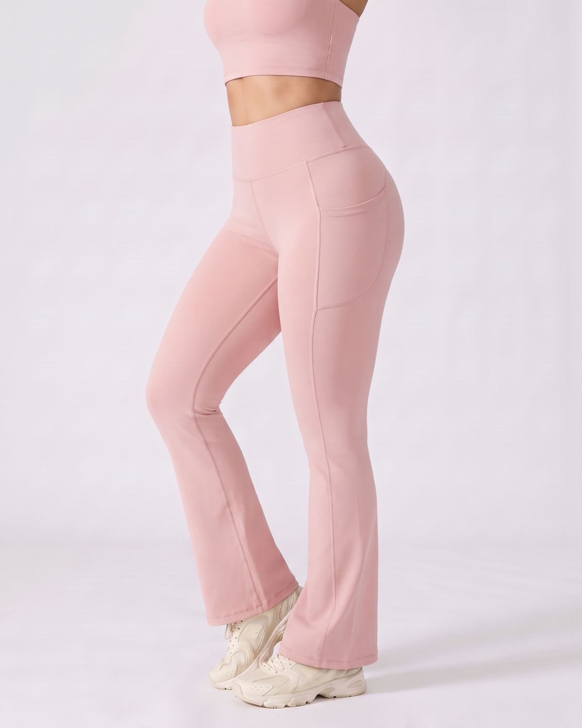 Legging Flare AIKISculpt rose porté, vu de trois quarts sur fond clair, de la poitrine aux pieds, évasé à partir du genou